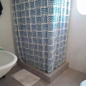 a bathroom with a blue and white shower curtain at LA ROTONDA in San Nicolás de los Arroyos