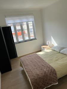 a bedroom with a large bed and a window at Casa da Luz in Angra do Heroísmo