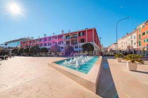 a fountain in the middle of a street with buildings at Apartments Antunovic in Umag