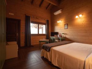 a bedroom with a bed and a desk and a window at Agri-Hotel Da Marianna Resort & Spa in Santa Domenica Vittoria