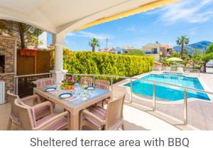 a patio with a table and chairs next to a swimming pool at Villa Canberk in Dalyan