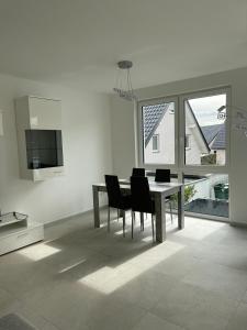 a dining room with a table and black chairs at 4 ZKB Neubauwohnung mit Stil in Bielefeld