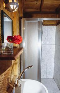 a bathroom with a sink and a shower with red flowers at Deep Ocean Camping-Adults Only in Faralya