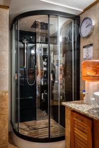 Una ducha de cristal en una cocina con reloj en la pared en Bahía Manzano Resort en Villa La Angostura