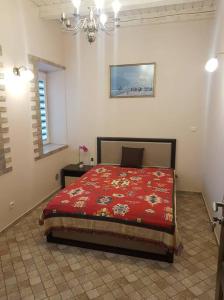 a bedroom with a red bed and a chandelier at Apartamentai, su nemokama vieta automobiliui in Saugos