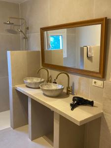 a bathroom with two sinks and a mirror at Casa El Sueño in Jávea