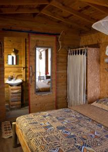 a bedroom in a log cabin with a bed and a sink at Deep Ocean Camping-Adults Only in Faralya