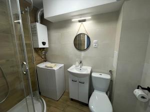 a bathroom with a toilet and a sink and a shower at Apartament Centrum in Łańcut