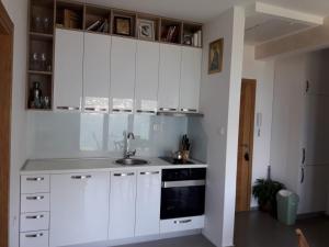 a kitchen with white cabinets and a sink at Teo's place in Kotor