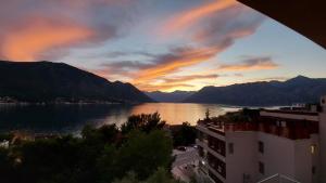 a view of a lake at sunset with a building at Teo's place in Kotor