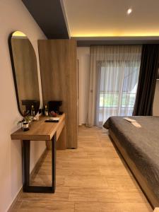 a bedroom with a bed and a desk with a mirror at Oasis in Sarti