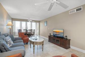 a living room with a couch and a tv at Tropical Oasis 809 in Naples