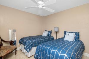 a bedroom with two beds and a ceiling fan at Tropical Oasis 809 in Naples +17 photos