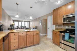 a large kitchen with wooden cabinets and appliances at Tropical Oasis 809 in Naples