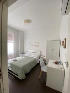 ein weißes Schlafzimmer mit einem Bett und einem weißen Schreibtisch in der Unterkunft Domus Corso Umberto 18 B&B in Pescara