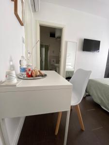 a white table and chair with a plate of food on it at Domus Corso Umberto 18 B&B in Pescara