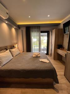 a bedroom with a large bed and a balcony at Oasis in Sarti