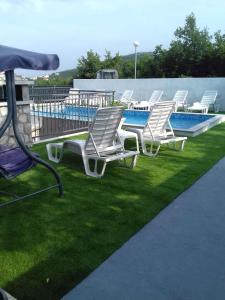 a group of lounge chairs and a swimming pool at Apartment Crikvenica 6 in Crikvenica