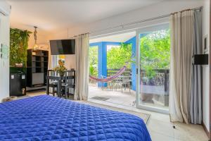 a bedroom with a blue bed and a balcony at Pousada Penareia Floripa in Florianópolis