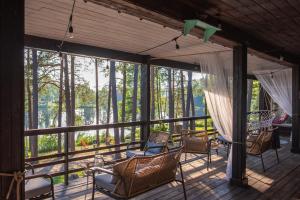 a screened in porch with chairs and windows at Tuba järveäärses puhkemajas - Saarjärve Puhkemaja in Tromsi