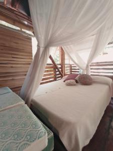 a bedroom with two beds and a canopy at La Casa en el Aire in Palomino