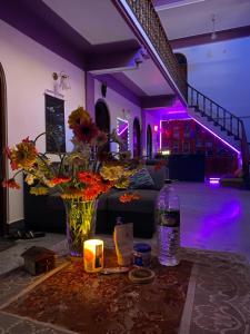 een kamer met een vaas met bloemen en een kaars bij Tashila Hostel in Gangtok