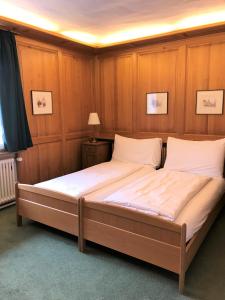 Gasthaus zum Goldenen Kreuz في Rafz: سرير كبير في غرفة مع ألواح خشبية