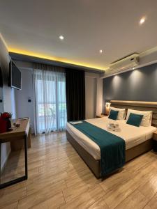 a hotel room with a bed and a desk and a television at Oasis in Sarti