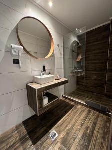 een badkamer met een wastafel, een spiegel en een douche bij Oasis in Sarti