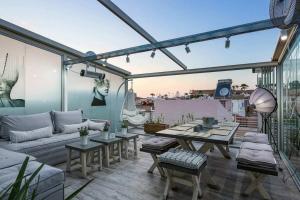 a patio with a couch and tables on a balcony at Eleanna's Luxury Home in Rethymno Town
