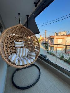 a hanging basket chair on a balcony with a window at Oasis in Sarti
