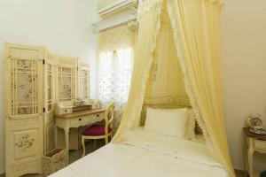 a bedroom with a canopy bed and a desk at Eleanna's Luxury Home in Rethymno