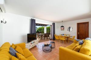 Una sala de estar con un sofá amarillo y una mesa. en Villa Flamingo by Villa Plus, en Playa Blanca