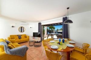 sala de estar con mesa y sofá amarillo en Villa Flamingo by Villa Plus, en Playa Blanca