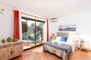 1 dormitorio con 1 cama y balcón con silla en Villa Dorada by Villa Plus, en Playa Blanca 29 fotos más