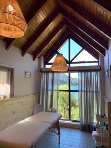 ein Schlafzimmer mit einem Bett und einem großen Fenster in der Unterkunft Bahía Manzano Resort in Villa La Angostura
