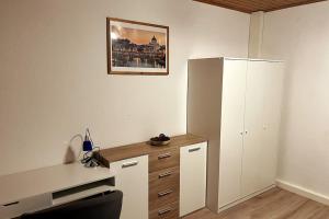 a office with a desk and a white refrigerator at Geräumige Ferienwohnung 90 sqm im Erholungsort in Bestwig