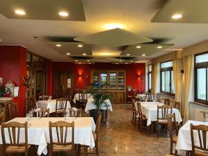 un restaurante con mesas y sillas con manteles blancos en Madonna della Neve, en Cessole