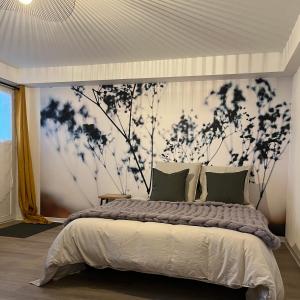 a bedroom with a large bed with a black and white wall at Les Cocons d AleXan Le studio balnéo aromathérapie 