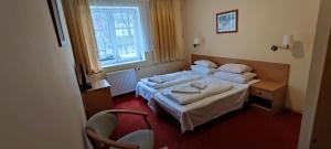 een hotelkamer met 2 bedden en een raam bij Wpadnij do Zosi - ex Pensjonat Emilia in Stronie Śląskie