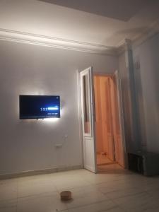um quarto com uma televisão de ecrã plano na parede em غرفة مفروشة خاصة الشيخ زايد للرجال فقط em Sheikh Zayed