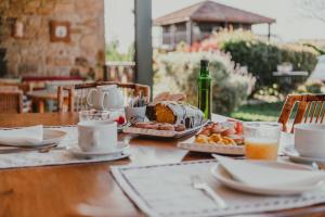 a table with a cake and a bottle of wine at Hotel Rural La Figar in Argüero