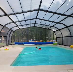 an indoor swimming pool with an open ceiling at La Demeure d'Othe in Sormery
