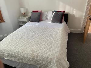 um quarto com uma grande cama branca e 2 almofadas em Perfect room 1 em Bristol