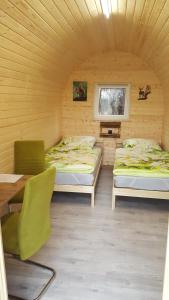 Glamping Pod im Wald mit Einzelbetten في نوردولز: غرفة بسريرين وطاولة وكراسي