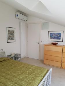 een slaapkamer met een groen bed en een houten dressoir bij La Mansarda di Corso Umberto in Pescara