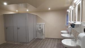 een badkamer met 3 wastafels en 3 toiletten bij Glamping Pod im Wald mit Einzelbetten in Nordholz
