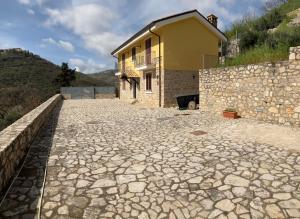 una casa con una entrada de piedra junto a una pared en Villa Nemo en Campodimele