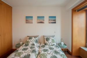 a bedroom with a bed and three paintings on the wall at Porto Metro-At-Home Apartment in Matosinhos