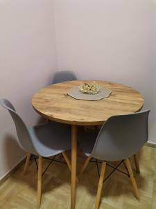 a wooden table with two chairs and a plate on it at Apartman Petrov in Pančevo